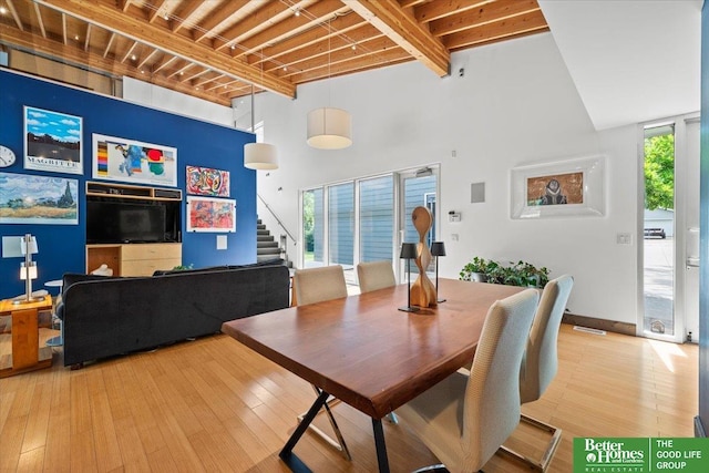5510 N 83rd St, Omaha, NE 68134 - dining space featuring beam ceiling, a high ceiling, stairway, and wood-type flooring
