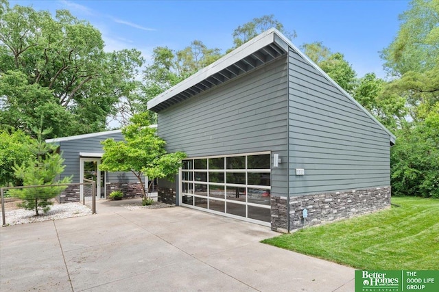 5510 N 83rd St, Omaha, NE 68134 - view of property exterior with stone siding, a detached garage, and a yard