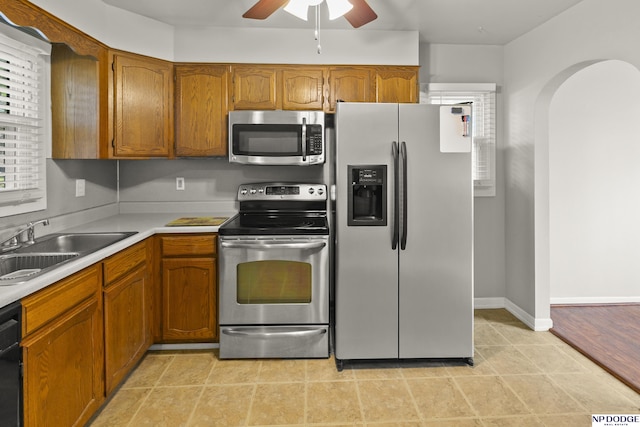 402 W 30th Ave, Bellevue, NE 68005 - kitchen featuring stainless steel appliances, ceiling fan, brown cabinets, arched walkways, and light countertops