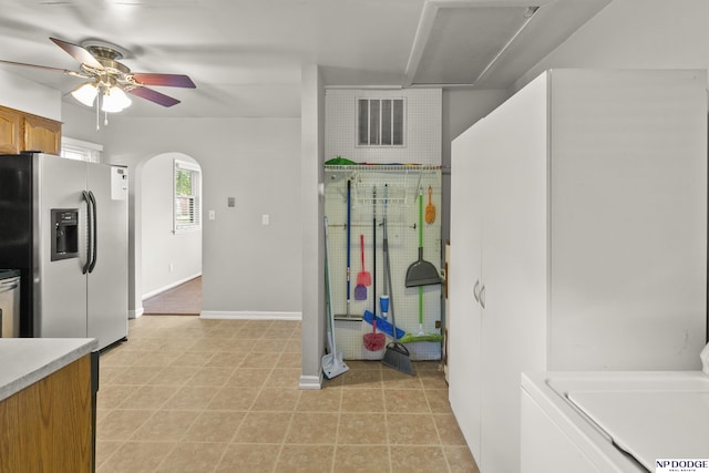 402 W 30th Ave, Bellevue, NE 68005 - kitchen featuring stainless steel fridge, a ceiling fan, light countertops, arched walkways, and brown cabinetry