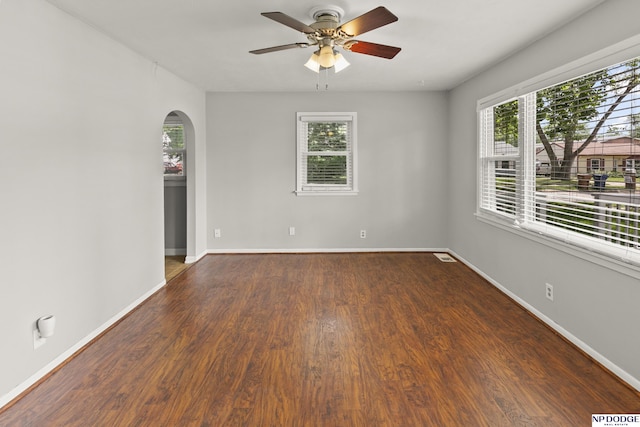 402 W 30th Ave, Bellevue, NE 68005 - spare room with arched walkways, a ceiling fan, and dark wood-style flooring