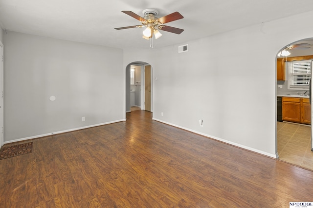 402 W 30th Ave, Bellevue, NE 68005 - spare room with arched walkways, a ceiling fan, and wood finished floors