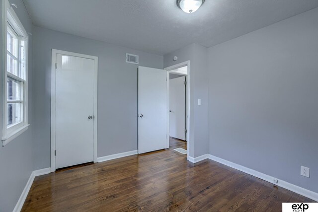 7622 Sherman Dr, Omaha, NE 68134 - unfurnished bedroom featuring baseboards and dark wood-type flooring