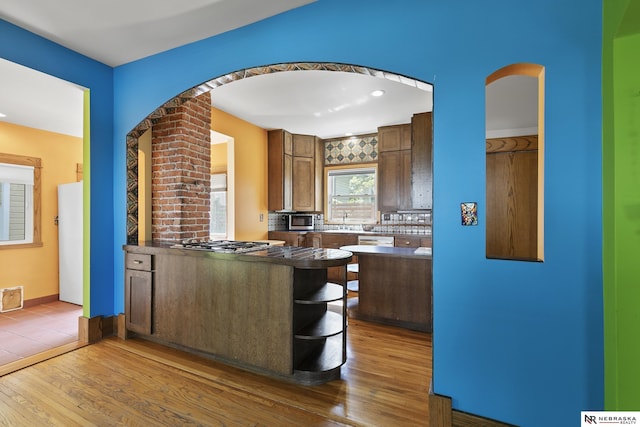 2615 C St, Lincoln, NE 68502 - kitchen featuring hardwood / wood-style flooring, appliances with stainless steel finishes, backsplash, dark countertops, and recessed lighting
