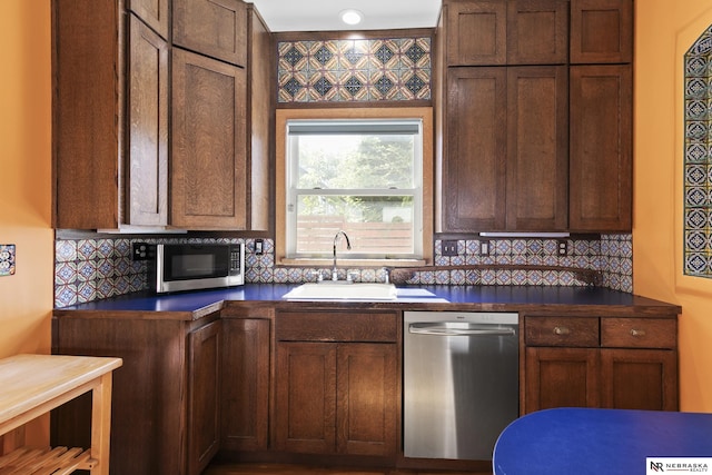 2615 C St, Lincoln, NE 68502 - kitchen featuring stainless steel appliances, dark countertops, and backsplash