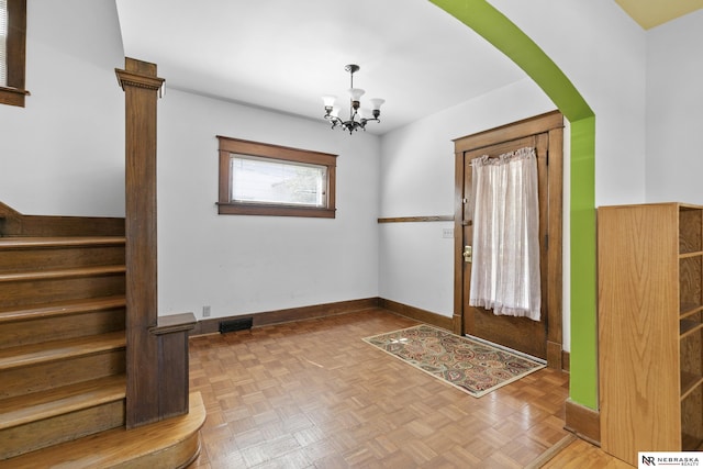 2615 C St, Lincoln, NE 68502 - foyer entrance with a chandelier, stairway, and arched walkways