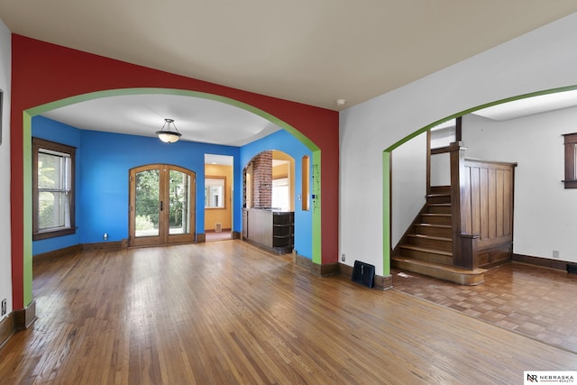 2615 C St, Lincoln, NE 68502 - unfurnished living room with wood finished floors, french doors, and stairs