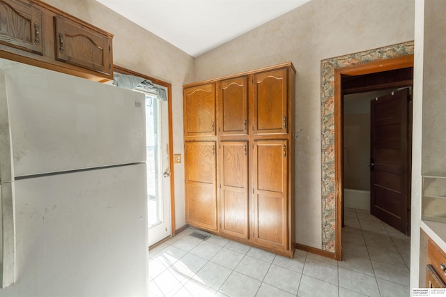 1621 Ridge Rd Lot B, Lot B, Fremont, NE 68025 - kitchen featuring freestanding refrigerator, light tile patterned flooring, brown cabinets, and plenty of natural light