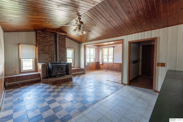 1621 Ridge Rd Lot B, Lot B, Fremont, NE 68025 - unfurnished living room featuring baseboard heating, wood walls, a wood stove, ceiling fan, and lofted ceiling