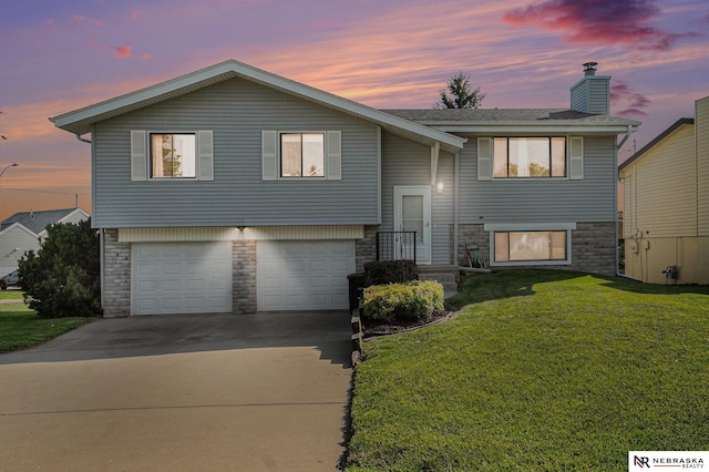 10605 Laurel Ave, Omaha, NE 68134 - bi-level home featuring stone siding, a garage, a chimney, a front lawn, and driveway