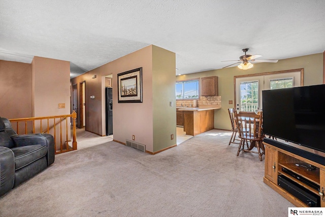 10605 Laurel Ave, Omaha, NE 68134 - living room featuring a ceiling fan, light colored carpet, and a textured ceiling