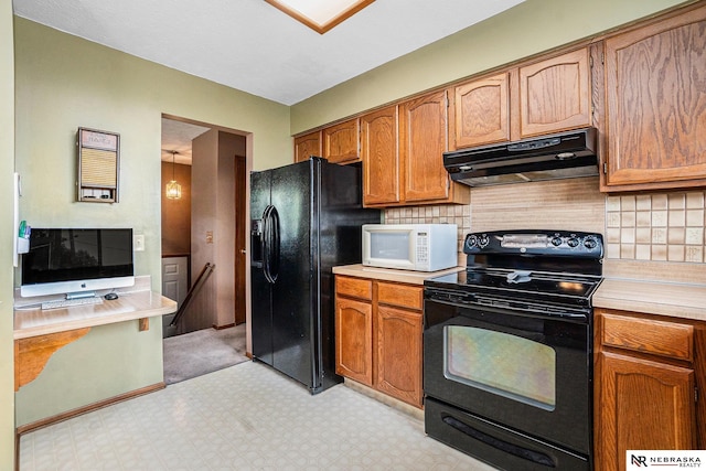 10605 Laurel Ave, Omaha, NE 68134 - kitchen with black appliances, under cabinet range hood, light countertops, light floors, and decorative backsplash