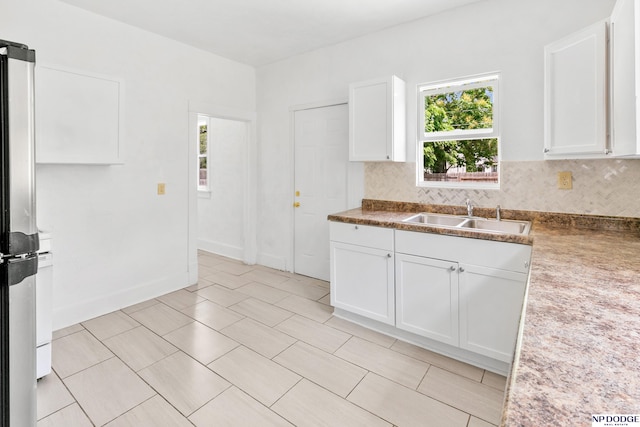 2738 Browne St, Omaha, NE 68111 - kitchen featuring plenty of natural light, freestanding refrigerator, and white cabinetry