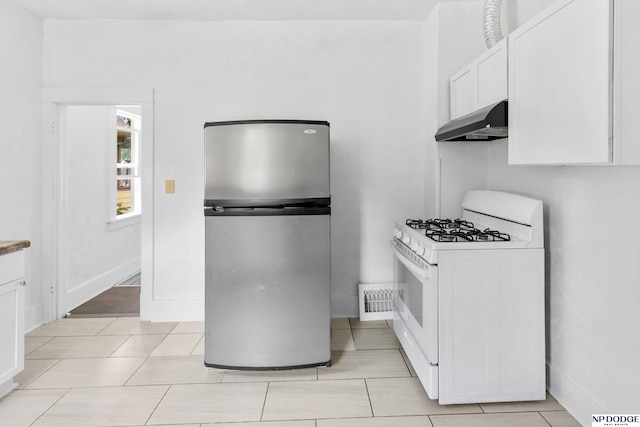 2738 Browne St, Omaha, NE 68111 - kitchen with freestanding refrigerator, white range with gas stovetop, under cabinet range hood, white cabinets, and light tile patterned flooring