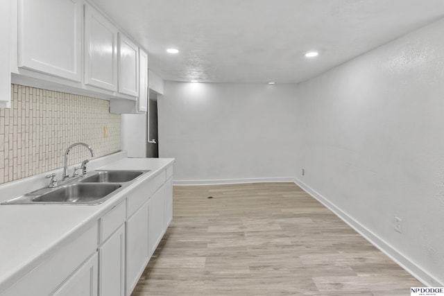 2738 Browne St, Omaha, NE 68111 - kitchen with white cabinets, tasteful backsplash, light countertops, light wood-style floors, and recessed lighting