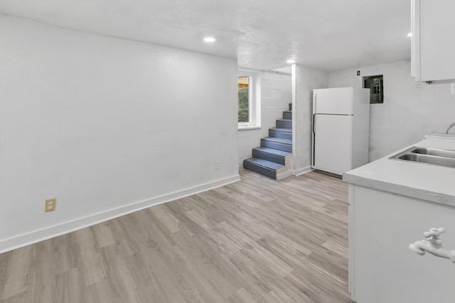 2738 Browne St, Omaha, NE 68111 - below grade area with freestanding refrigerator, stairs, light wood finished floors, and recessed lighting