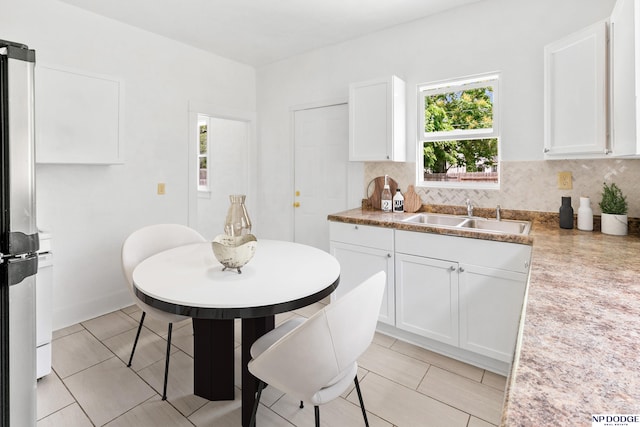 2738 Browne St, Omaha, NE 68111 - kitchen with plenty of natural light, freestanding refrigerator, white cabinetry, and decorative backsplash