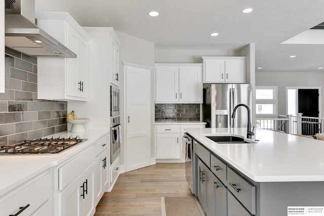 20709 Woodridge Dr, Gretna, NE 68028 - kitchen with wall chimney exhaust hood, appliances with stainless steel finishes, gray cabinets, light wood-style flooring, and light countertops