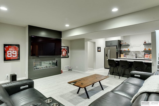 20709 Woodridge Dr, Gretna, NE 68028 - living area with bar with sink, recessed lighting, and a large fireplace