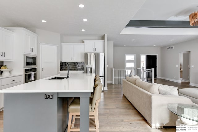20709 Woodridge Dr, Gretna, NE 68028 - kitchen featuring stainless steel appliances, recessed lighting, open floor plan, and light wood-style floors
