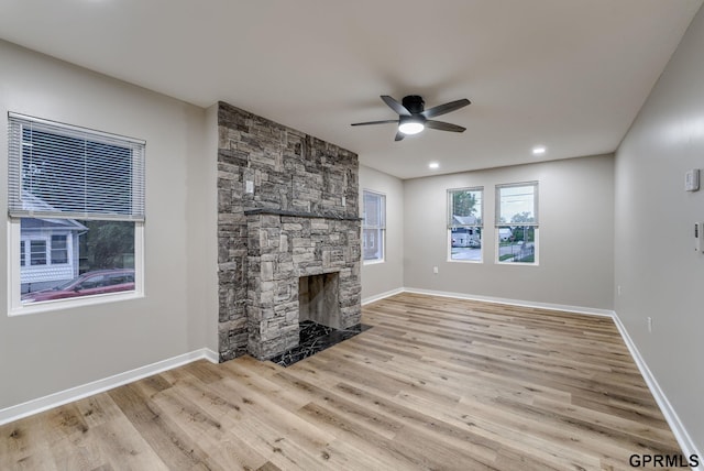 2551 Meredith Ave, Omaha, NE 68111 - unfurnished living room featuring a ceiling fan, light wood-type flooring, a stone fireplace, and recessed lighting