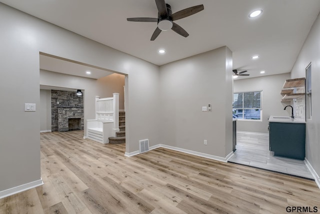 2551 Meredith Ave, Omaha, NE 68111 - unfurnished living room featuring ceiling fan, light wood-style floors, stairs, recessed lighting, and a fireplace