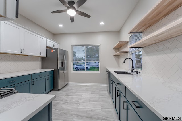 2551 Meredith Ave, Omaha, NE 68111 - kitchen with open shelves, stainless steel refrigerator with ice dispenser, white cabinetry, ceiling fan, and tasteful backsplash