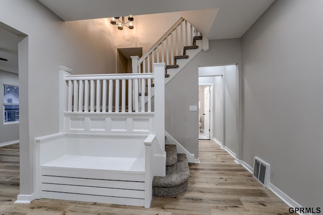 2551 Meredith Ave, Omaha, NE 68111 - staircase featuring wood finished floors and a chandelier