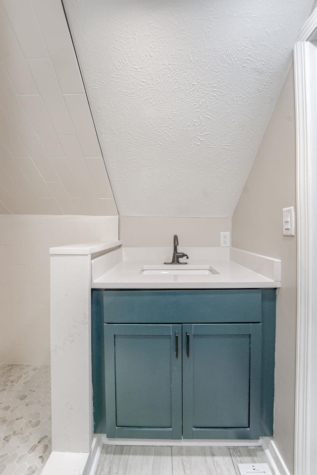 2551 Meredith Ave, Omaha, NE 68111 - bathroom with vanity, a tile shower, and a textured ceiling