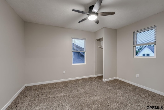 2551 Meredith Ave, Omaha, NE 68111 - unfurnished bedroom with dark carpet, a ceiling fan, a closet, and a textured ceiling