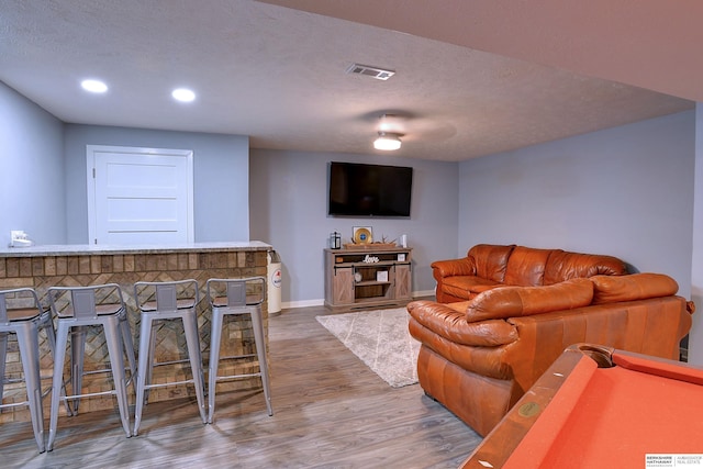 4625 S 222nd St, Elkhorn, NE 68022 - living room with wood finished floors, recessed lighting, a bar, and a textured ceiling