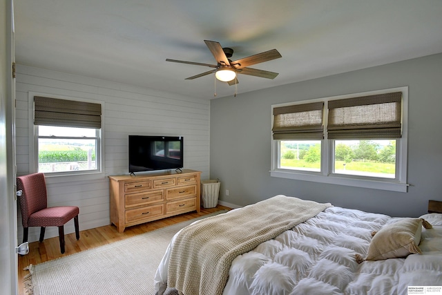 4625 S 222nd St, Elkhorn, NE 68022 - bedroom featuring light wood-style floors, multiple windows, wooden walls, and ceiling fan