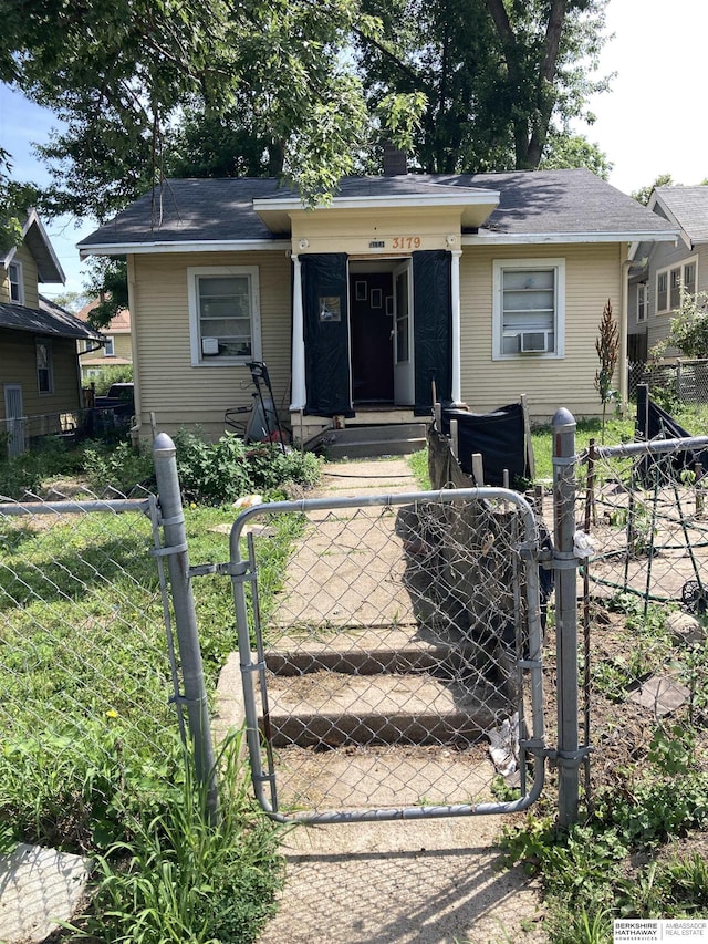 3179 Larimore Ave, Omaha, NE 68111 - view of front of house featuring a fenced front yard, a gate, a chimney, and cooling unit