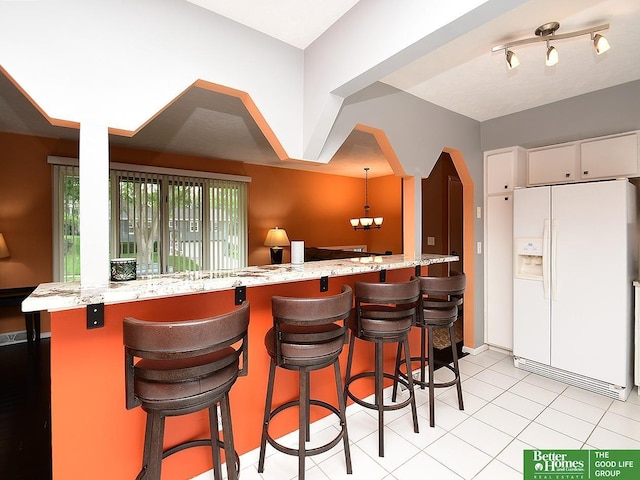 9705 Cady Ave, Omaha, NE 68134 - kitchen with white refrigerator with ice dispenser, white cabinetry, a breakfast bar, and light stone countertops
