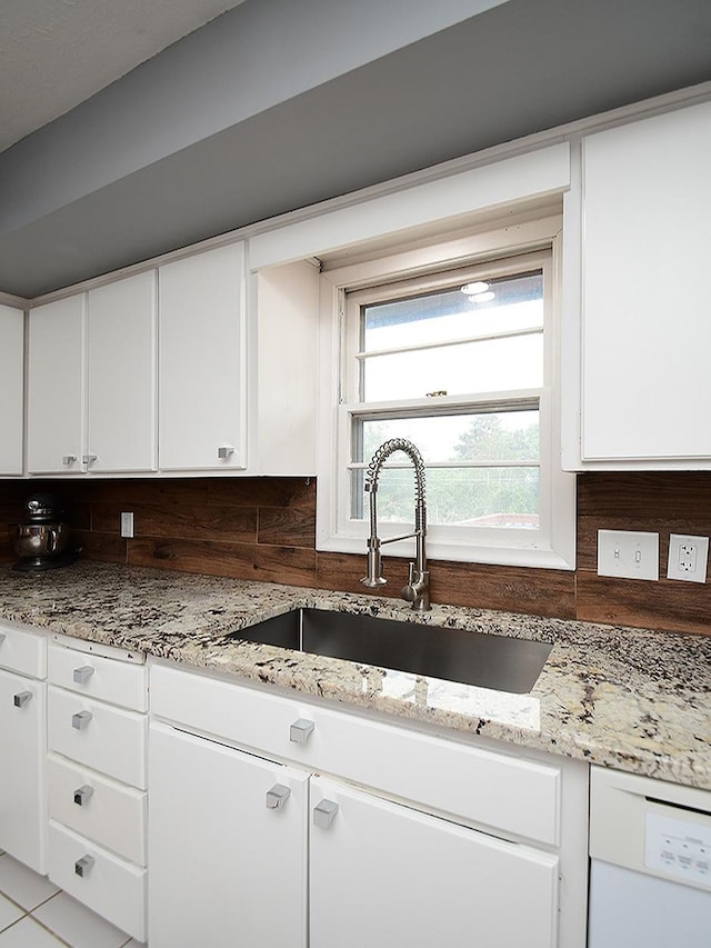 9705 Cady Ave, Omaha, NE 68134 - kitchen featuring white dishwasher, tasteful backsplash, white cabinetry, and light stone countertops