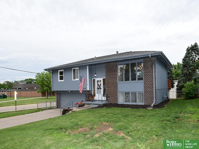 9705 Cady Ave, Omaha, NE 68134 - raised ranch featuring brick siding, a front yard, an attached garage, and concrete driveway