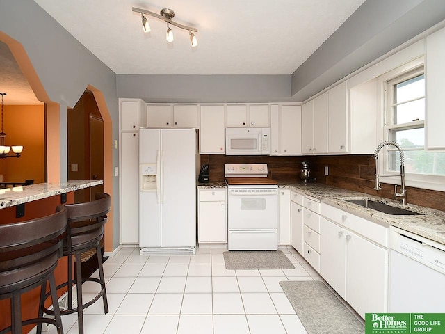 9705 Cady Ave, Omaha, NE 68134 - kitchen with white appliances, white cabinets, light stone counters, and a chandelier