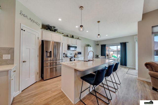 7420 Isidore Dr, Lincoln, NE 68516 - kitchen with stainless steel appliances, decorative backsplash, white cabinetry, light wood-style flooring, and recessed lighting