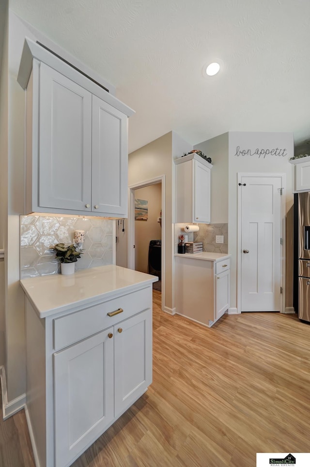 7420 Isidore Dr, Lincoln, NE 68516 - kitchen featuring decorative backsplash, stainless steel fridge with ice dispenser, light countertops, light wood finished floors, and recessed lighting