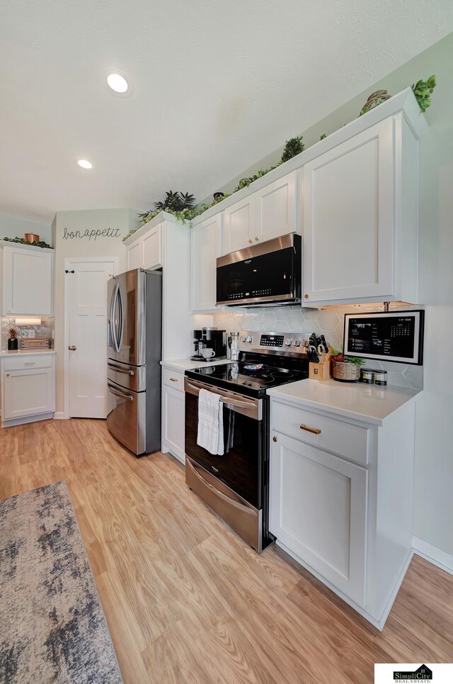 7420 Isidore Dr, Lincoln, NE 68516 - kitchen featuring stainless steel appliances, white cabinets, light wood-type flooring, and recessed lighting
