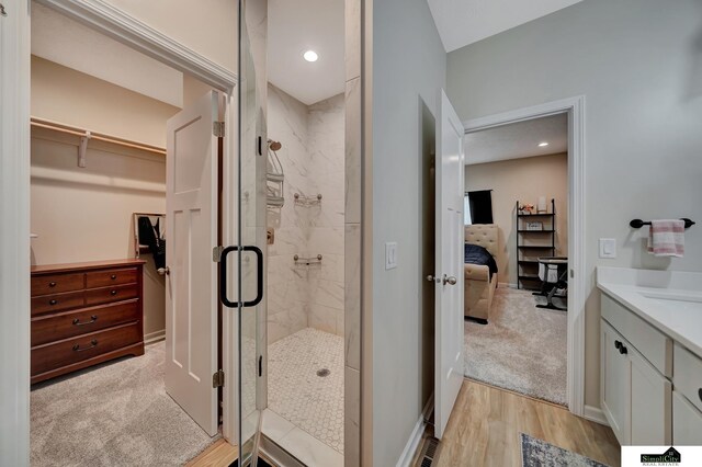 7420 Isidore Dr, Lincoln, NE 68516 - full bathroom featuring ensuite bath, a shower stall, vanity, wood finished floors, and a walk in closet