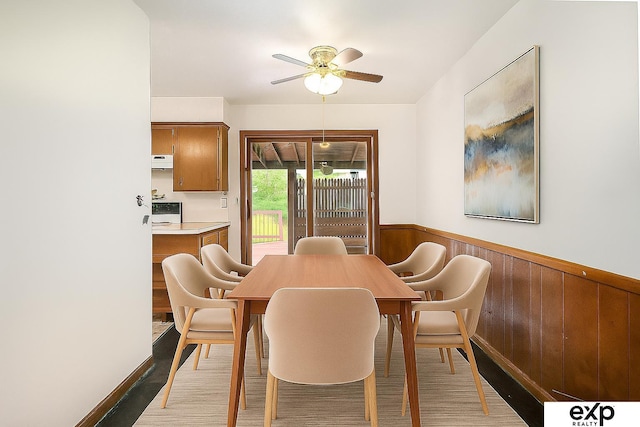 813 Janes View St, Papillion, NE 68046 - dining room with a wainscoted wall, ceiling fan, light wood-type flooring, and wood walls