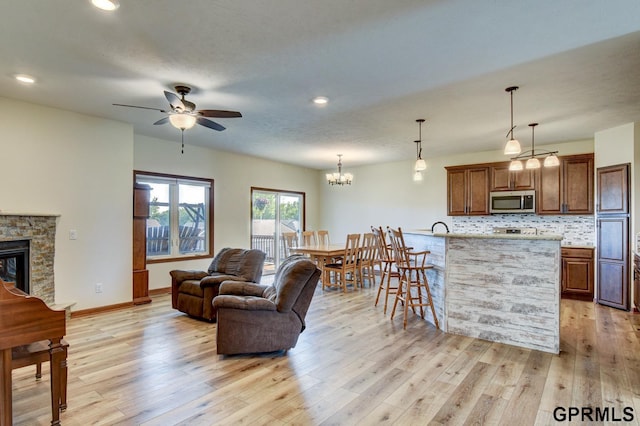 3320 Fairway Dr, Plattsmouth, NE 68048 - living room featuring a ceiling fan, light wood-type flooring, a fireplace, recessed lighting, and a chandelier