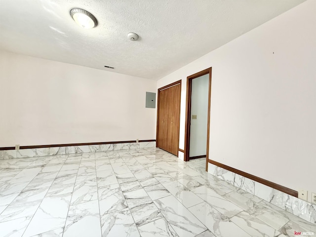 724 W Belmont Ave, Lincoln, NE 68521 - unfurnished room with light marble finish floors, a textured ceiling, and electric panel