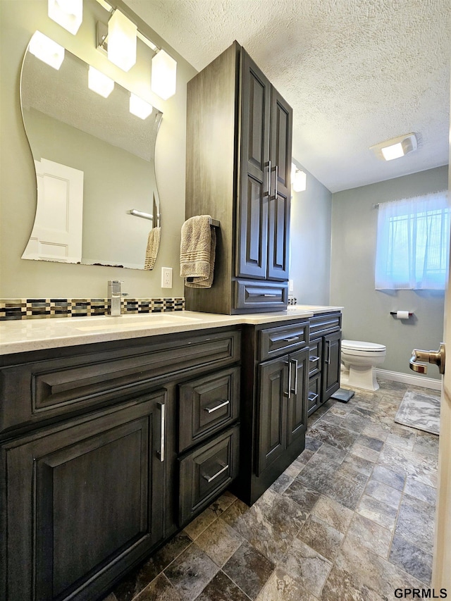 108 W Ridge St, Sutton, NE 68979 - bathroom with double vanity, stone tile floors, and a textured ceiling