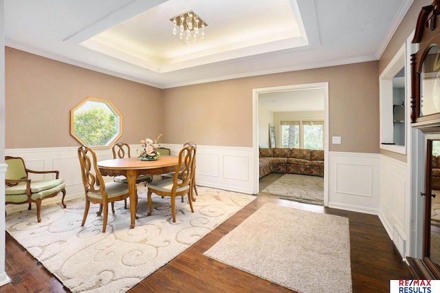 605 S 120th Ave, Omaha, NE 68154 - dining room featuring a raised ceiling, a wainscoted wall, a chandelier, wood finished floors, and crown molding