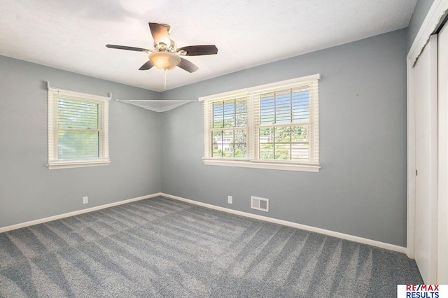 605 S 120th Ave, Omaha, NE 68154 - unfurnished bedroom with multiple windows, dark carpet, and a closet