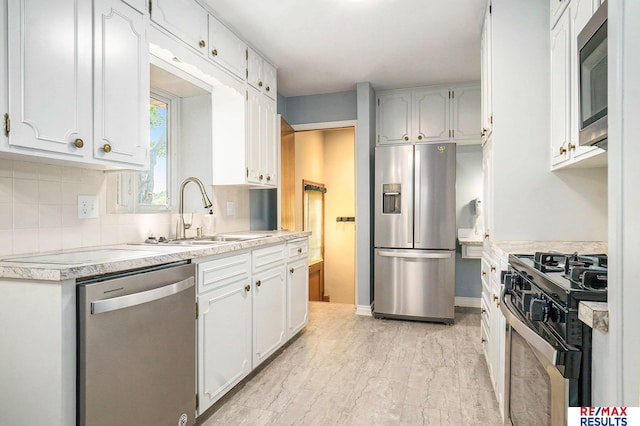 605 S 120th Ave, Omaha, NE 68154 - kitchen featuring appliances with stainless steel finishes, decorative backsplash, light countertops, and white cabinetry