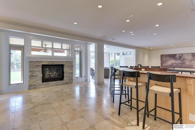 14341 Hamilton St, Omaha, NE 68154 - kitchen featuring open floor plan, recessed lighting, a stone fireplace, a breakfast bar area, and a ceiling fan
