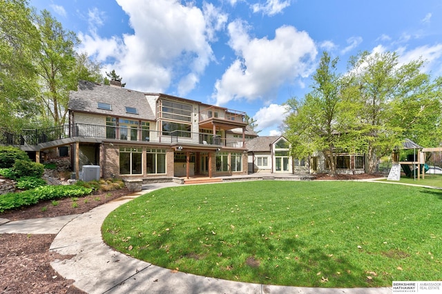 14341 Hamilton St, Omaha, NE 68154 - rear view of property with a playground, brick siding, a yard, a chimney, and a balcony